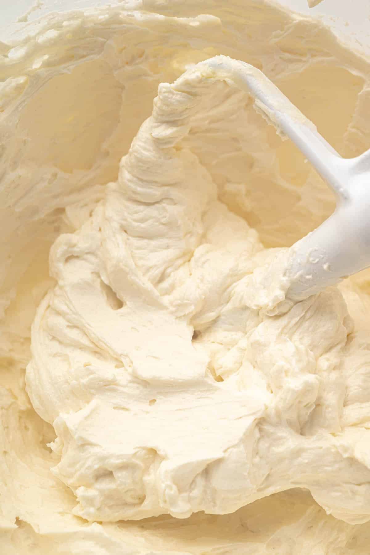 Close up ermine frosting beating mixed with a paddle attachment.
