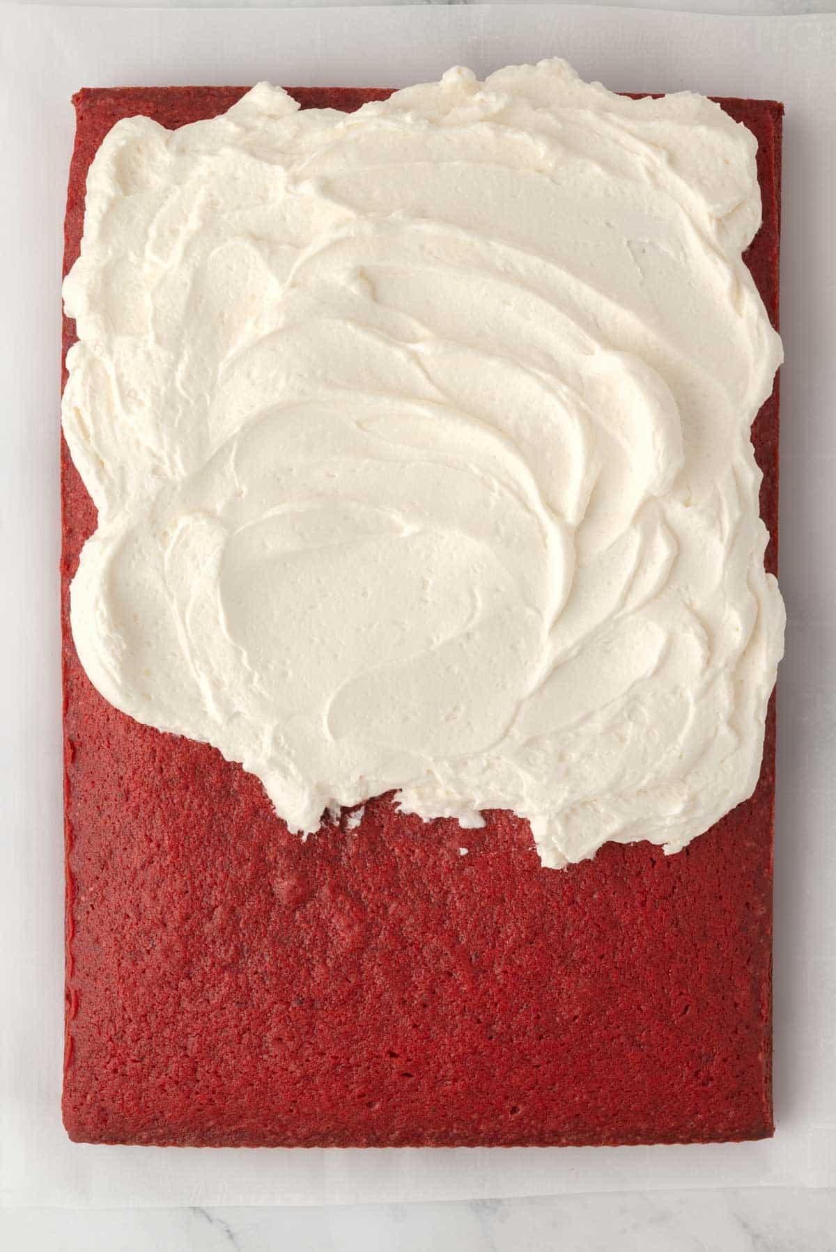 Overhead view of red velvet cake with ermine frosting spread on top.