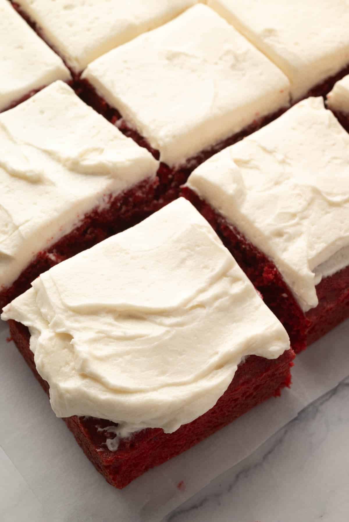Overhead view of cut pieces of red velvet cake with ermine frosting.