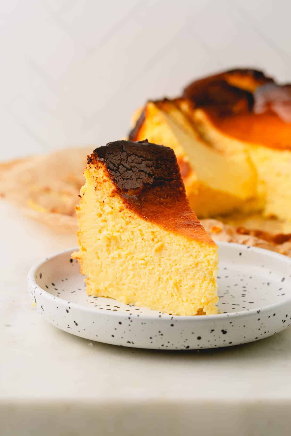 A slice of basque cheesecake on a small plate.