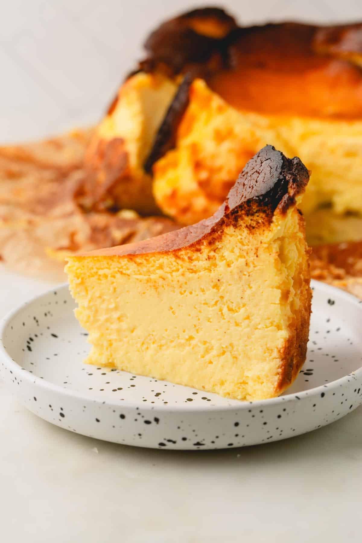 A slice of basque cheesecake on a small plate.