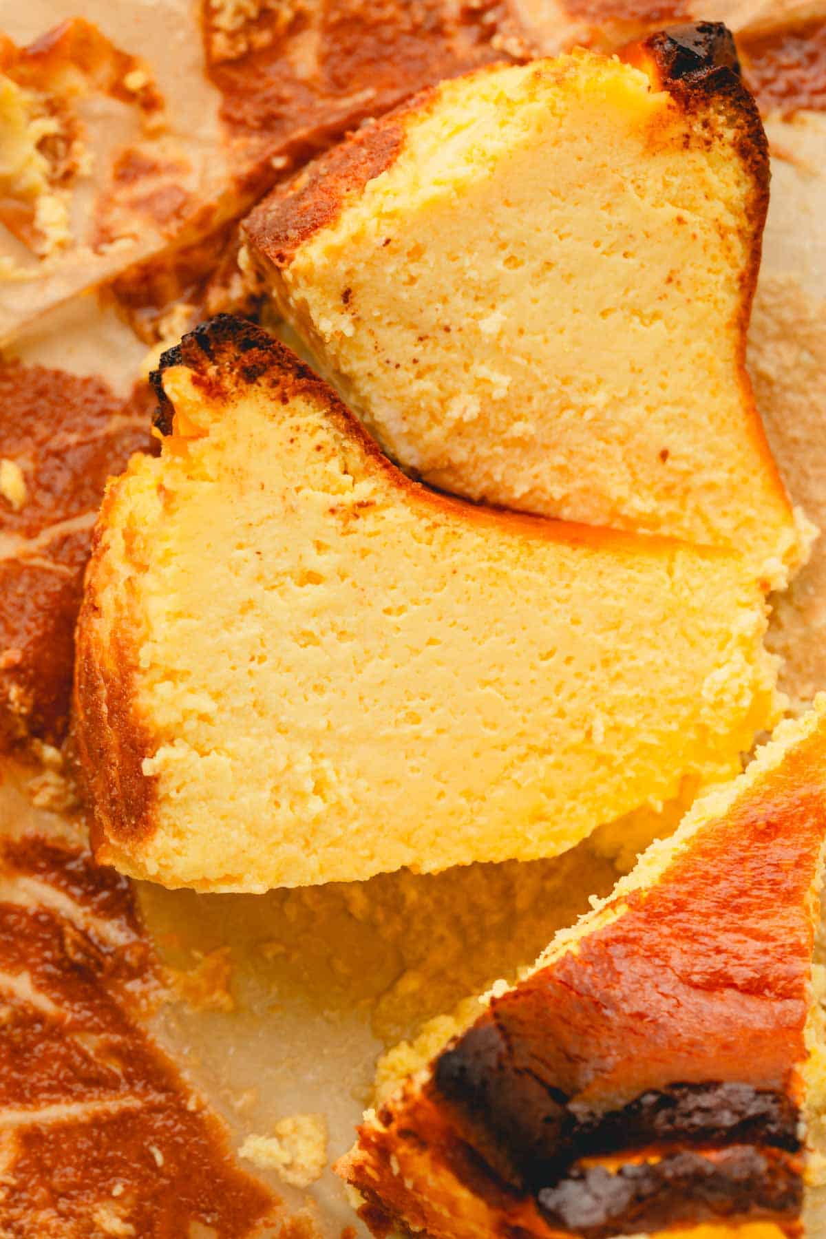 A close up shot of two slices of basque cheesecake on their sides.