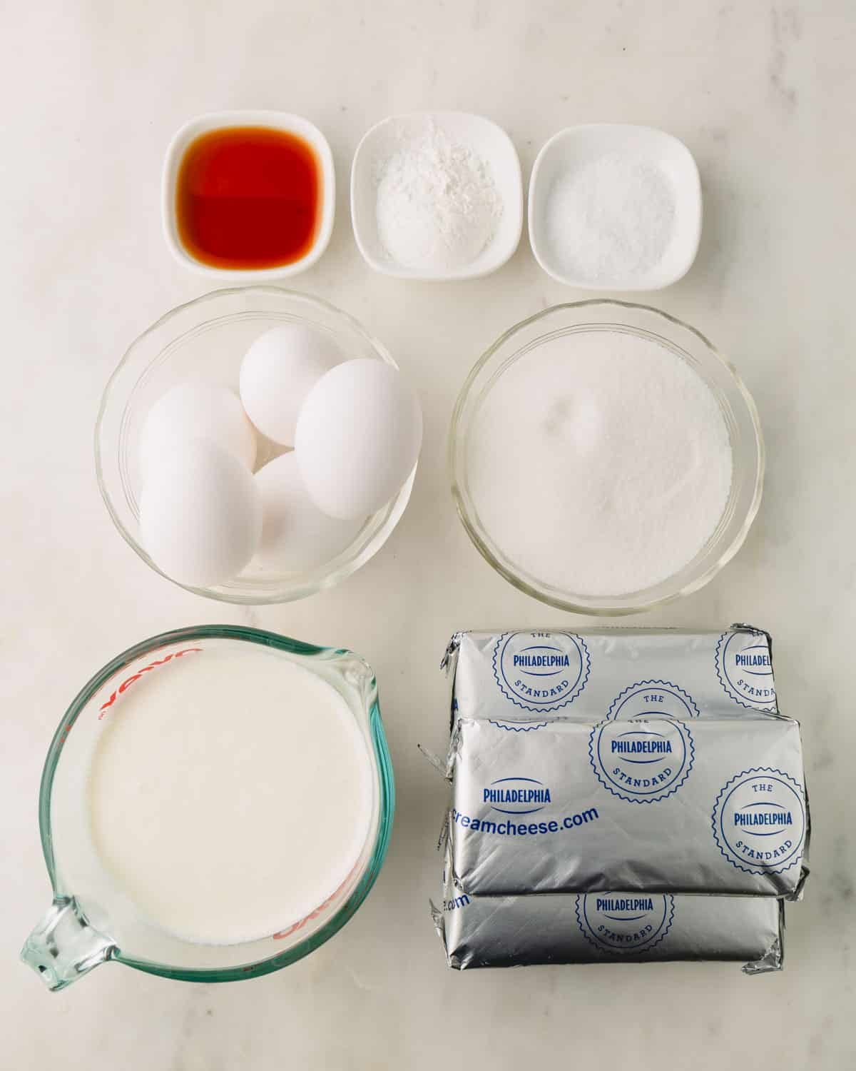 Ingredients for basque cheesecake in individual bowls.