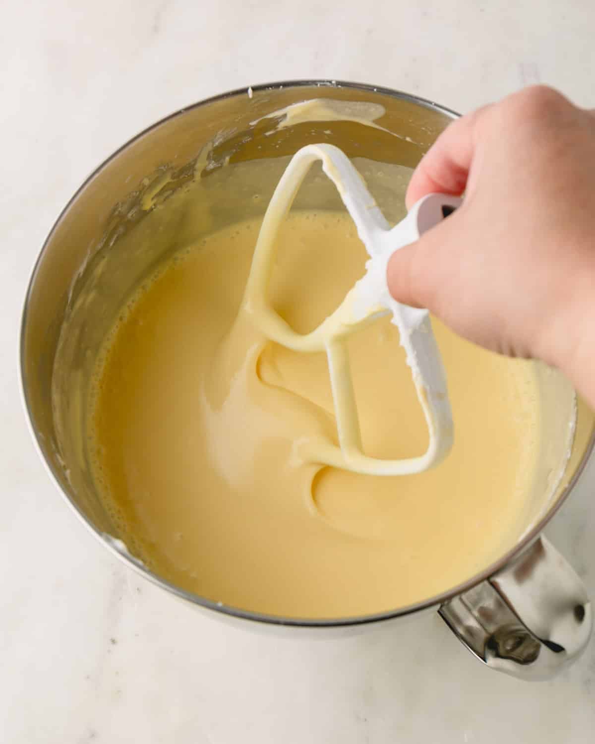Smooth cheesecake batter with a paddle attachment dipped.