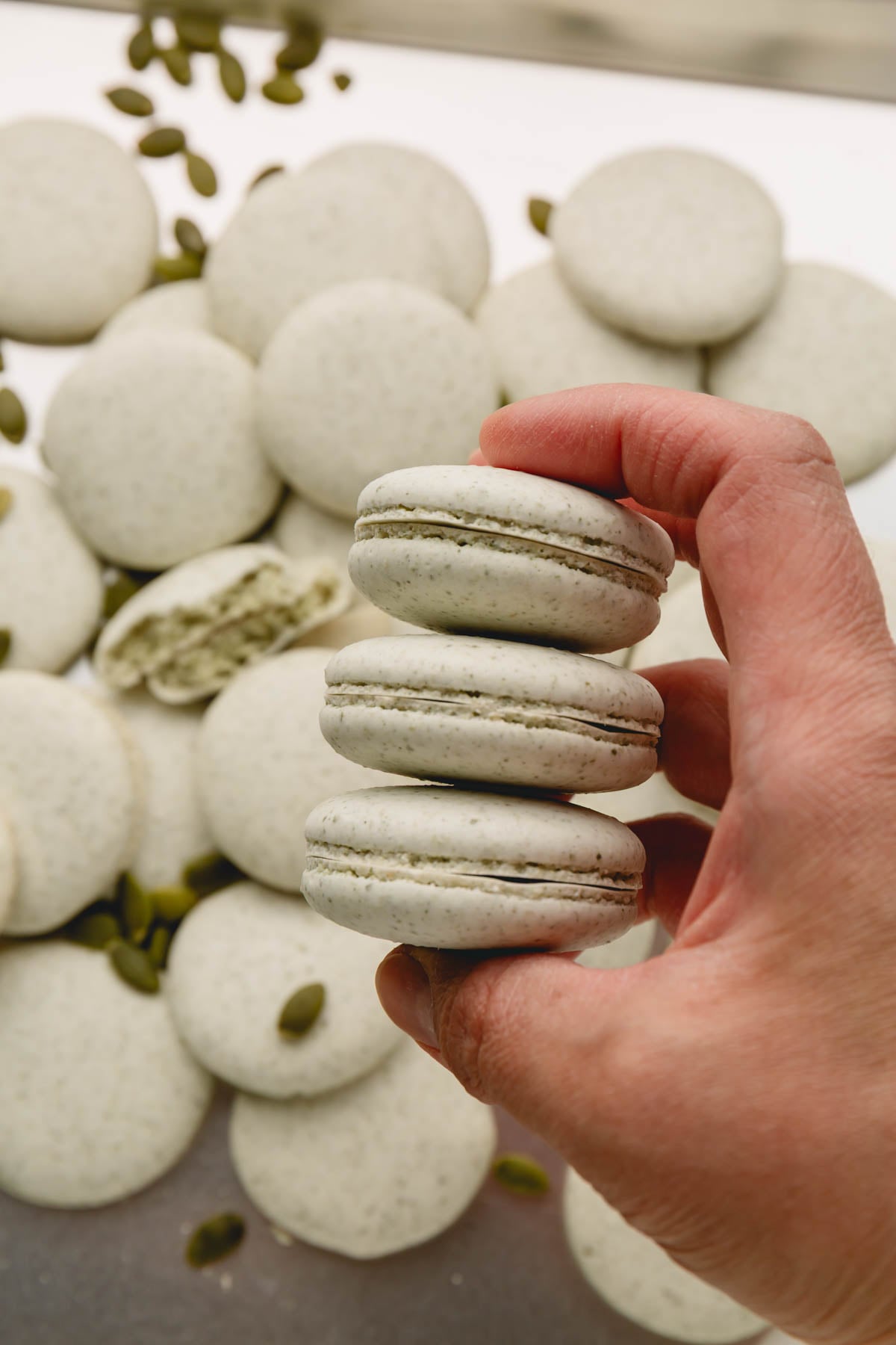 3 paired baked macaron shells held in a hand.