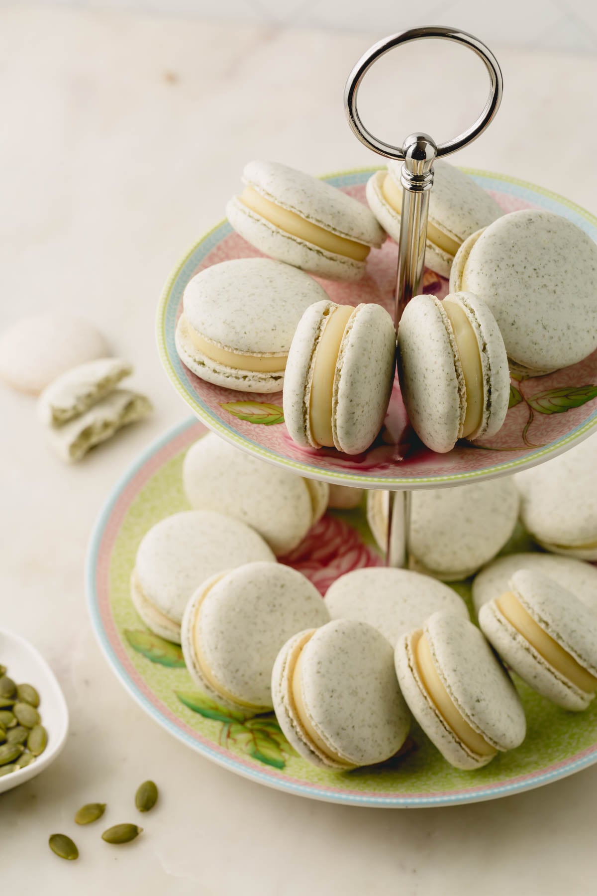 Filled macarons arranged on a two-tier dessert platter.