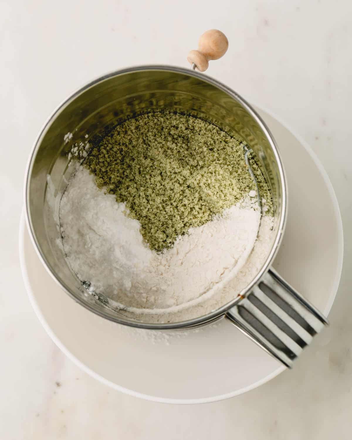 Ground sunflowers, powdered sugar and flour in a sifter.