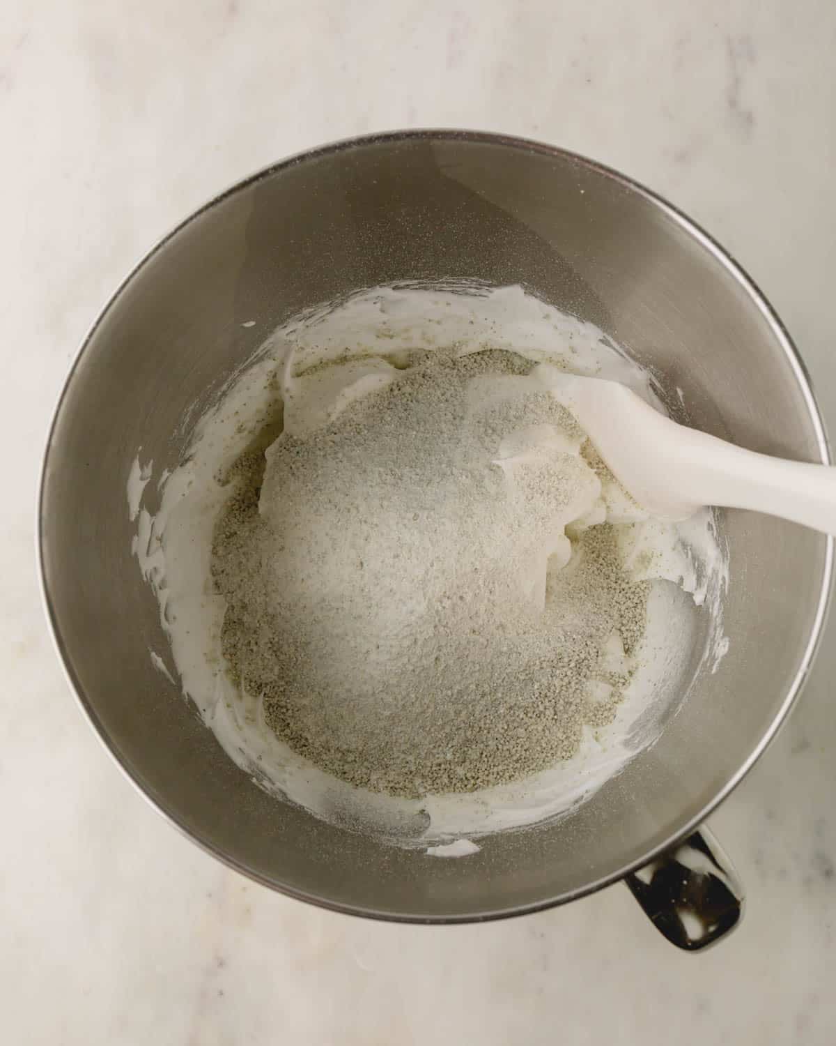Dry ingredients are sifted into the bowl with the white meringue.